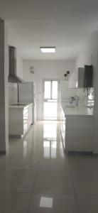 a white kitchen with white counters and a window at Dream house! in Qiryat Bialik