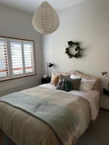 a bedroom with a bed with a wreath on the wall at Stylish Townhouse in Havelock North