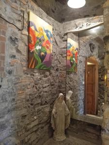 een standbeeld van een vrouw in een kamer met schilderijen aan de muur bij Bed and Breakfast Papillon in Perledo