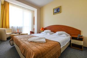 Una habitación de hotel con una cama con toallas blancas. en Hotel Rio en Jupiter