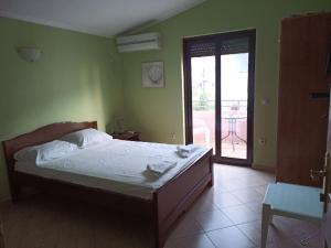 a bedroom with a bed and a door to a patio at Apartments Normannia in Dobra Voda