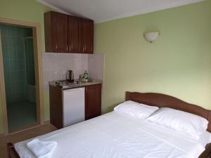 a bedroom with a white bed and a sink at Apartments Normannia in Dobra Voda