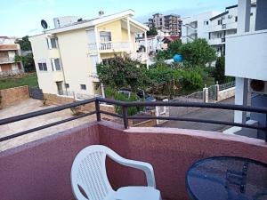 a white chair sitting on top of a balcony at Apartments Normannia in Dobra Voda
