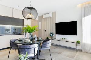 a dining room with a table and chairs and a tv at Fly Apartments Medulin - 50m from the Beach - NEW 2024 in Medulin