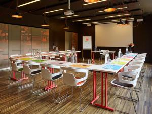 una sala conferenze con un lungo tavolo e sedie di 25hours Hotel Zürich West a Zurigo