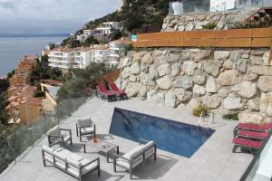 un patio con sillas y una mesa junto a la piscina en Agi Joan Margarit, en Roses