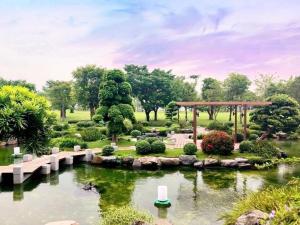 a garden with a pond and a gazebo at Vinhome Landmark Suites in Ho Chi Minh City