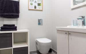 La salle de bains blanche est pourvue de toilettes et d'un lavabo. dans l'établissement Friends and Family Vacation Apartments, à Riga