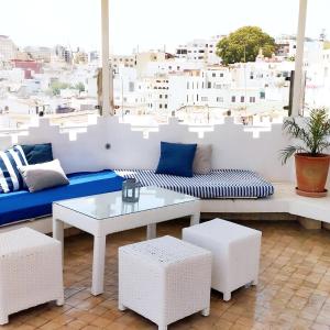 a living room with a couch and a table at Maison Médina, terrasse panoramique in Tangier