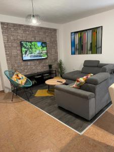Una sala de estar con un sofá y un televisor. en Apartments Leona, en Rogoznica