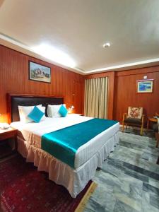Habitación de hotel con cama grande con almohadas azules en Hotel One Karachi en Karachi