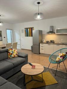 Una sala de estar con un sofá y una mesa y una cocina. en Apartments Leona, en Rogoznica