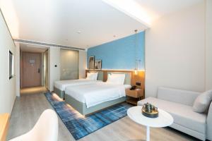 una camera d'albergo con un letto e un divano di Country Inn & Suite by Radisson, Wuhan Optics Valley Technology Convention and Exhibition Center a Wuhan