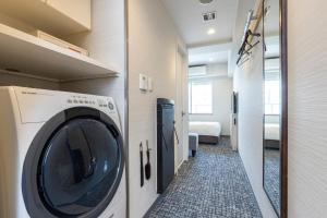 a washer and dryer in a room with a bedroom at Tokyu Stay Tsukiji - Tokyo Ginza Area in Tokyo