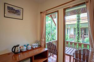 a room with a door leading to a balcony at Bangtao Village Resort - SHA in Bang Tao Beach