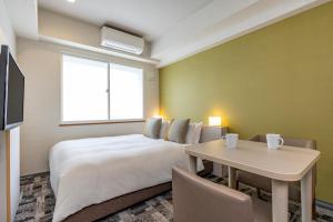 a bedroom with a large bed and a table at Tokyu Stay Tsukiji - Tokyo Ginza Area in Tokyo