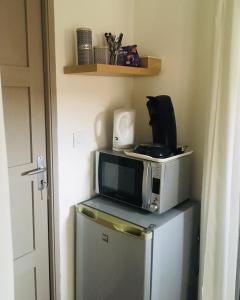 a microwave sitting on top of a refrigerator at Les chambres d'Ursule in Tartas