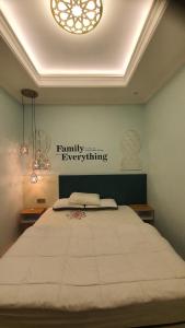 a bedroom with a large white bed with a chandelier at Malang and Bromo Tour Riverside in Malang