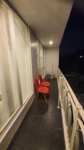 a red chair sitting on a balcony next to a window at Malang and Bromo Tour Riverside in Malang