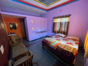 a bedroom with a bed and a table in it at DANDELI NAKADI Home Stay in Dandeli +16 photos