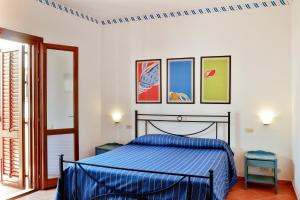 ファヴィニャーナにあるレジデンス シロッコ エ トラモンターナのベッドルーム1室(青いベッド1台付)