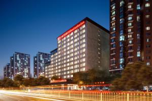 ein Gebäude mit einem roten Schild an der Seite in der Unterkunft Hilton Garden Inn Beijing West Railway Station in Peking