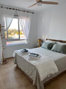 a bedroom with a bed with a fan and a window at Bambu in Carboneras +24 photos
