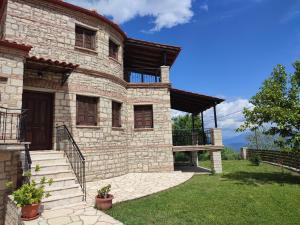 une grande maison en pierre avec des escaliers dans la cour dans l'établissement Mansion Michalis, à Rodavgi