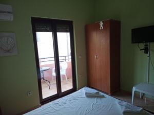 Apartments Normannia في دوبرا فودا: غرفة نوم بسرير وباب زجاجي منزلق