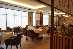 a restaurant with tables and chairs and large windows at Hilton Garden Inn Pune Hinjawadi in Pune