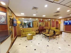 una sala de espera con sofás y TV de pantalla plana. en Hotel One Karachi en Karachi