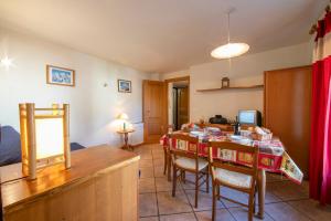 una cucina e una sala da pranzo con tavolo e sedie di Résidence Jardins d'Androsace 17 - Happy Rentals a Chamonix-Mont-Blanc