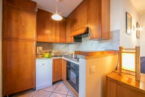 a kitchen with wooden cabinets and a white dishwasher at Résidence Jardins d'Androsace 17 - Happy Rentals in Chamonix-Mont-Blanc