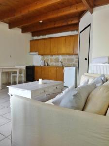 a living room with a white couch in a kitchen at Thalassa Apartments in Rethymno