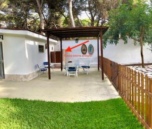 a patio with a table and chairs under a canopy at Bungalow Fatamorgana in Pulsano +21 photos