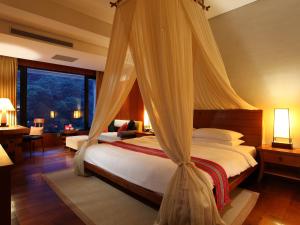 a bedroom with a bed with a mosquito net at Volando Urai Spring Spa & Resort in Wulai