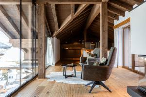 an attic living room with a chair and a table at Bergresort Zugspitze Ehrwald by ALPS RESORTS in Ehrwald