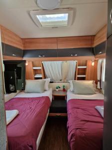 吉洛梅Magnifique grande Caravane aux Gorges de Daluis的小型客房中间设有两张床。