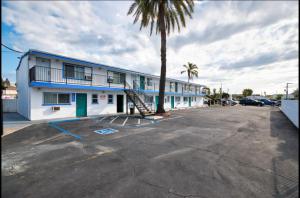 a building with a palm tree in a parking lot at Sunny Sands Inn in Costa Mesa