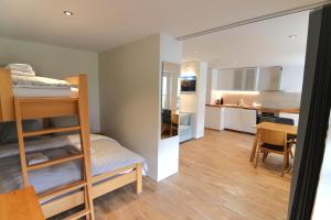 ein kleines Zimmer mit einem Etagenbett und einer Küche in der Unterkunft Jäggi 44 by Arosa Holiday in Arosa