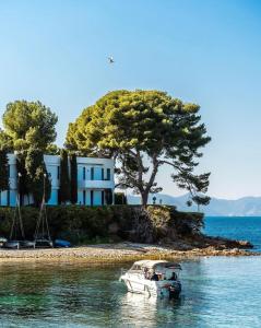 un barco en el agua frente a una casa en Ravissant T1 au bord de l'eau Juan Les Pins, en Antibes