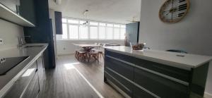 a kitchen with a table and a clock on the wall at Las Gaviotas in Viveiro