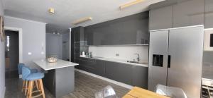 a kitchen with gray cabinets and a table and chairs at Las Gaviotas in Viveiro +18 photos