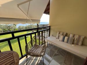 einen Balkon mit einer Bank, einem Tisch und Stühlen in der Unterkunft Olive Tree Bay in Lefokastro + 30 Fotos