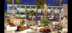 un centro comercial con palmeras y un edificio en Apartment Sea View Alcaidesa 2 beds Golf & Beach, en Alcaidesa