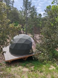 a tent sitting on a wooden platform in the woods at Camping le Colorado in Rustrel