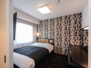 APA Hotel Namba Shinsaibashi Higashi tesisinde bir odada yatak veya yataklar