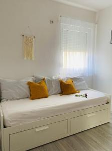 1 dormitorio con 1 cama blanca grande con almohadas amarillas en Apartments Ivana, en Zubovići