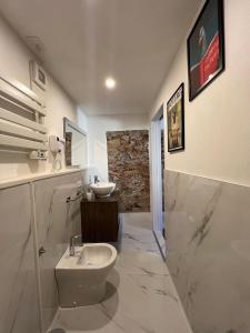 a white bathroom with a sink and a toilet at La Matilde in Viareggio