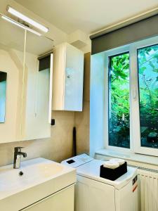 a white kitchen with a sink and a window at Bri Central Apartment in Deva +23 photos